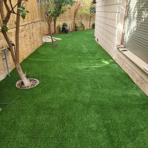 דשא סינתטי, עצים, אדם עובד בגינה