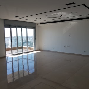 רצפה מבריקה בחדר ריק עם חלונות גדולים