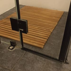 רצפת עץ במקלחת עם דלת זכוכית