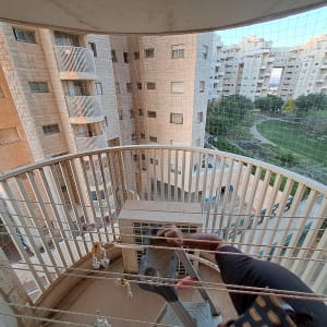 רשת הגנה מותקנת על מרפסת למניעת כניסת יונים