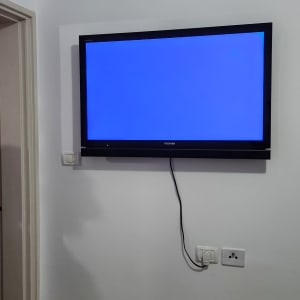 טלוויזיה תלויה על הקיר עם כבל חשמל