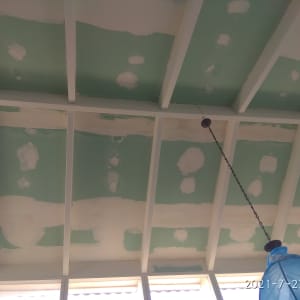 תקרה עם תיקוני צבע וטיח על לוחות ירוקים