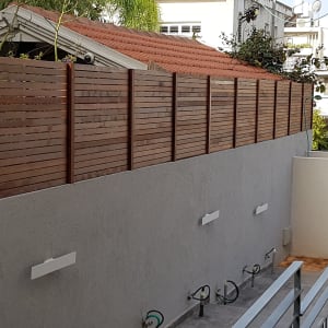 גדר עץ חומה על קיר בטון אפור