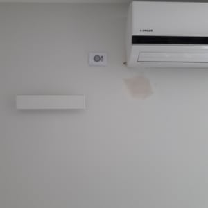 מזגן מותקן על קיר עם שלט בקרת אקלים