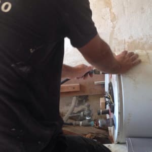 אדם עובד על דוד שמש עם כלים