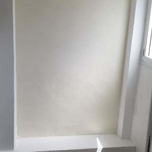 קיר צבוע בלבן עם סימני צבע שונים