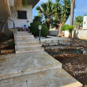 צינור השקיה מונח על האדמה ליד מדרגות