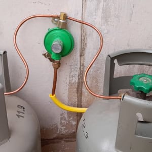 שני בלוני גז מחוברים לווסת ירוק עם צינור נחושת