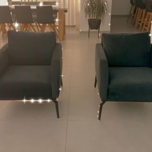 שני כורסאות מרופדות בצבע כהה על רצפה בהירה