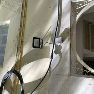 תאורת חוץ מותקנת על קיר עם כבלים חשמליים