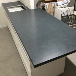 משטח שיש כהה על ארון מטבח לבן