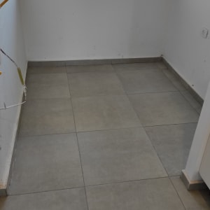 רצפה נקייה עם אריחים אפורים ליד חלון