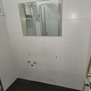 קיר אמבטיה עם חיבורים לצנרת מים