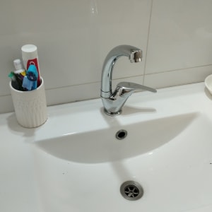 ברז כרום מעל כיור לבן בחדר אמבטיה