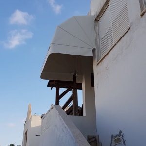 סוכך לבן מותקן מעל גרם מדרגות חיצוני