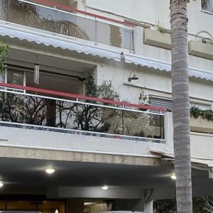 סוככים לבנים מותקנים מעל מרפסות בבניין מגורים