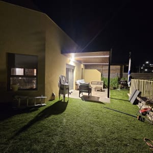 פרגולה מאלומיניום עם תאורה מעל מרפסת בלילה