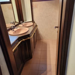 שני כיורים עם ברזים על משטח עץ בחדר אמבטיה