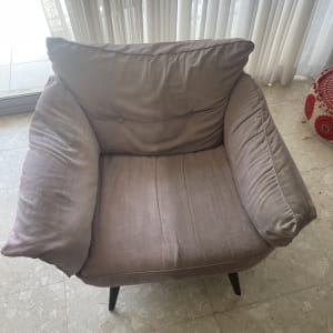 כורסה אפורה עם רגליים שחורות על רצפת שיש