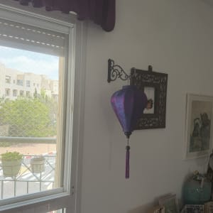 מנורה סגולה תלויה על קיר ליד חלון