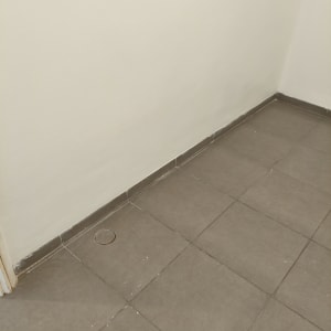 קיר צבוע ורצפת אריחים אפורה