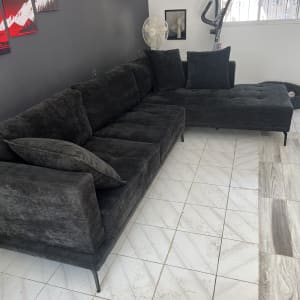 ספה כהה על רצפה לבנה עם כתמים