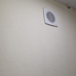 מאוורר קיר מותקן על קיר לבן