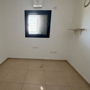 חדר ריק עם חלון ומדף על הקיר