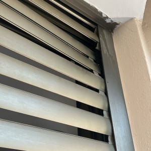 Close-up of metallic window shutters partially open