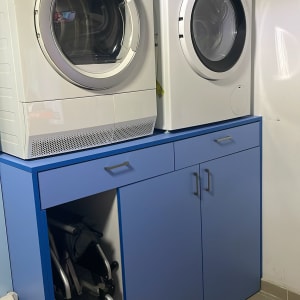 מכונת כביסה ומייבש על ארון כחול