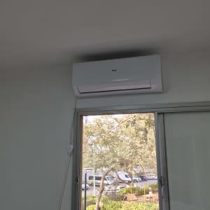 מזגן מותקן על קיר ליד חלון