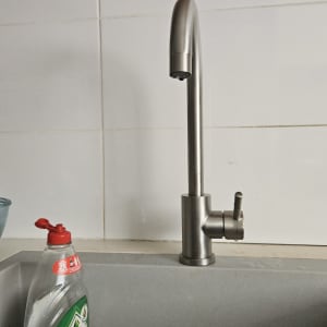 ברז נירוסטה בכיור עם בקבוק סבון כלים