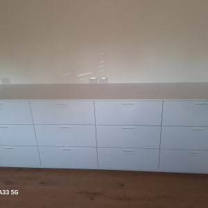 ארון מגירות לבן עם ידיות פשוטות על רצפת עץ
