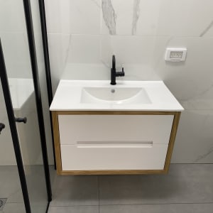 כיור לבן עם ברז שחור ומגירות עץ