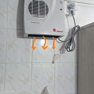 תנור חימום חשמלי מותקן על קיר בחדר אמבטיה