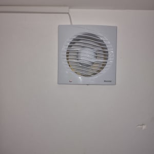 מאוורר קיר מותקן על קיר לבן