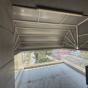 מרפסת עם סוכך מתקפל מעל נוף עירוני