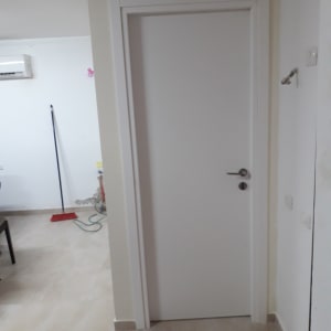 דלת לבנה עם משקוף גבס בקיר פנימי