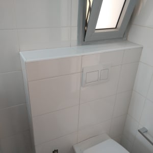 לחצני הדחה כפולים על קיר אריחים לבנים