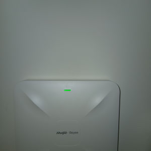 נתב רשת מותקן על קיר עם נורית חיווי ירוקה