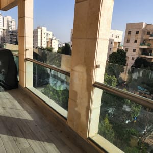 מעקה זכוכית במרפסת עם נוף לבניינים