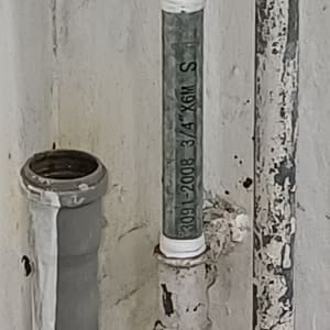 צינורות ומחברים על קיר, כולל ברז ישן