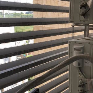 רשת מתכת על חלון עם מזגנים חיצוניים