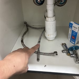 צנרת מתחת לכיור עם חיבורים וכלים