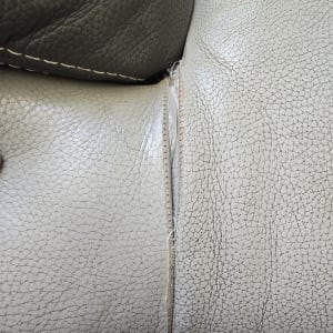 קרע בריפוד עור אפור עם תפרים חשופים