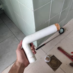 יד מחזיקה צינור ליד כלים של אינסטלטור