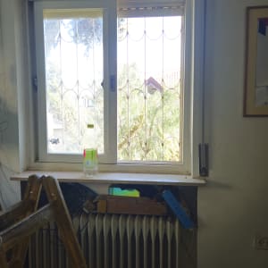 חלון עם תריסים וסולם בחדר פנימי