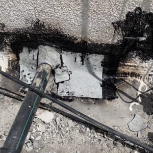 איטום קיר עם חומר שחור וצינורות