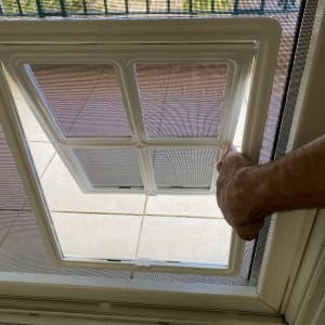 יד מחזיקה מסגרת אלומיניום של חלון רשת