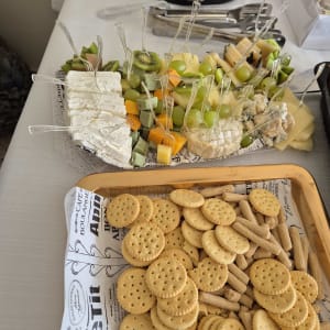מגש גבינות ופירות עם קרקרים על שולחן קייטרינג